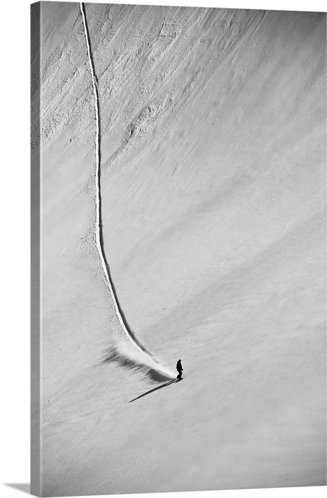 A professional, freeriding snowboarder on a wide open snowy slope making new tracks; British Columbia, Canada