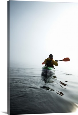 A Sea Kayaker Paddles Into Thick Fog On On A Calm Morning In Alaska