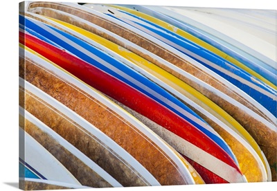 A stack of colorful longboard surfboards placed on the beach; Waikiki, Oahu, Hawaii