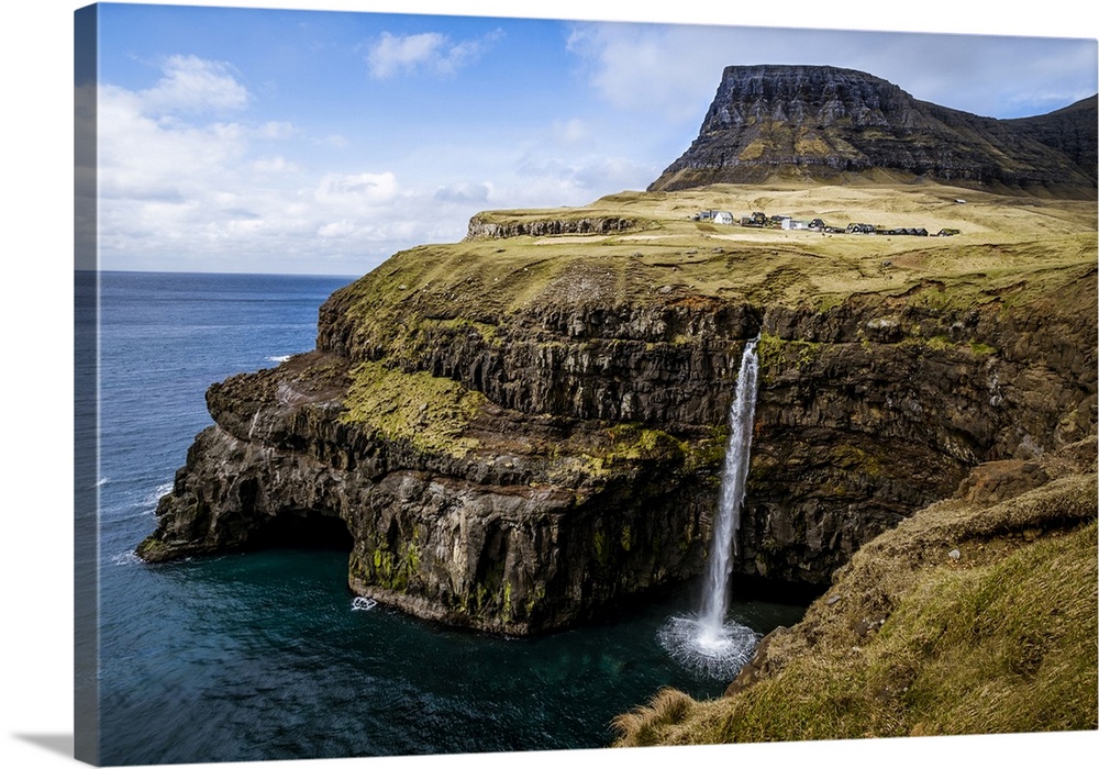 A waterfall cascades down a dramatic rockface on the Faroe Islands.