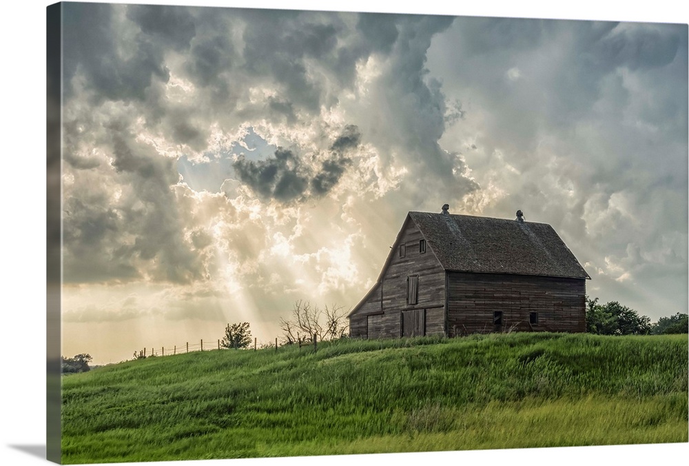 Abandoned barn with storm clouds converging overhead; Nebraska, United States of America