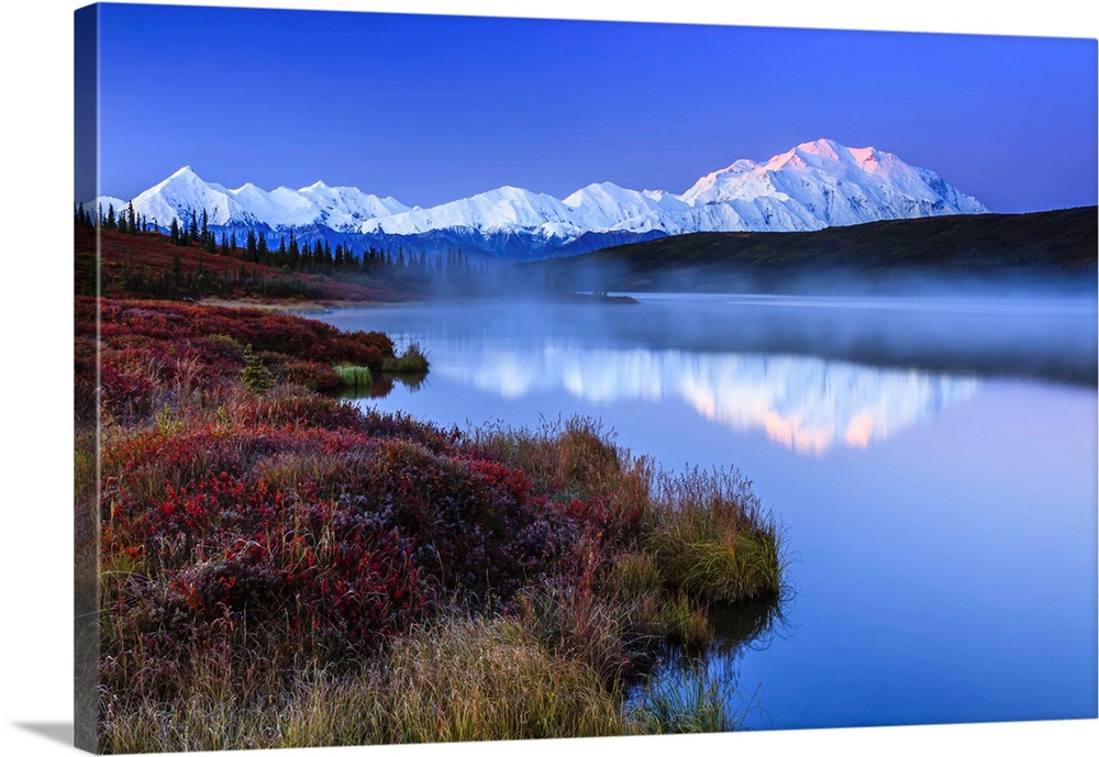 Reflection of the Alaska Range mountains in the tranquil water of Wonder Lake at sunrise in Denali National Park and Prese...