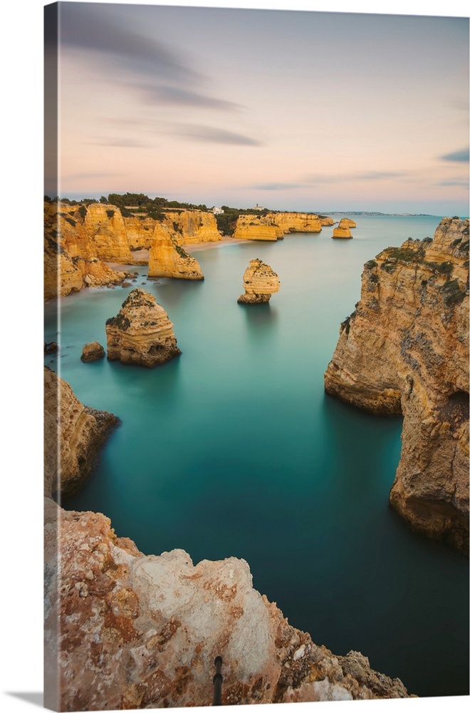 Iconic rock formations and turquoise water of the Atlantic Ocean at Praia da Marinha along the Atlantic coast in Caramujei...