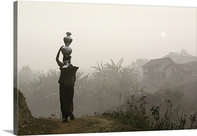 Bru Tribeswoman Carrying Water Pots On Her Head At Sunrise; India