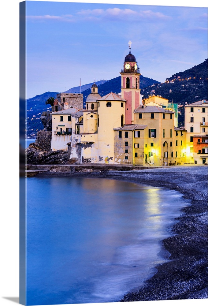 Buildings illuminated by lights along the water's edge at sunrise, Camogli, Liguria, Italy.