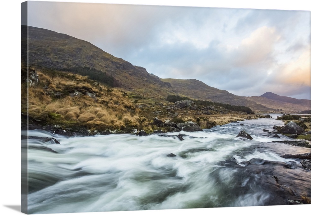 Cascades on a river in the Black Valley in Kerry with the MacGillycuddy's Reeks in the background on a cloudy day; County ...