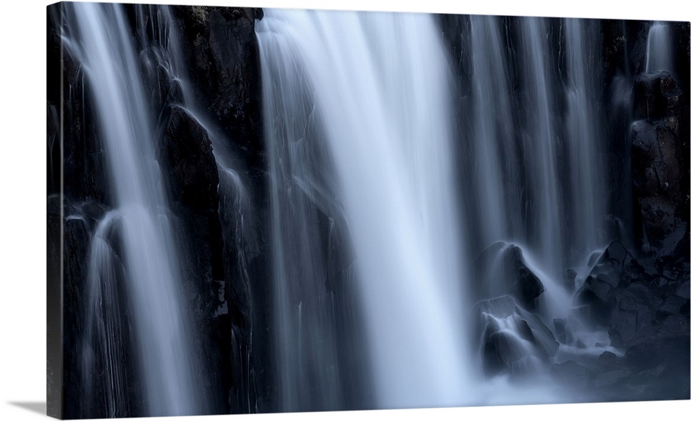 Close-up of a series of waterfalls, the soft blur of flowing water over black rock, Iceland.