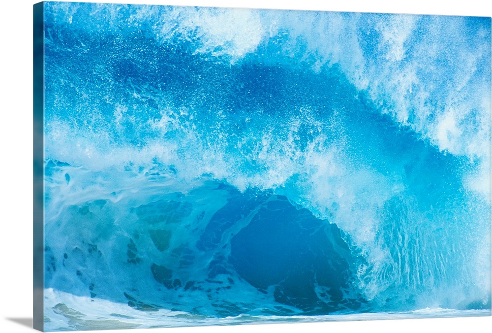 Up-close photograph of huge swell crashing down into ocean.
