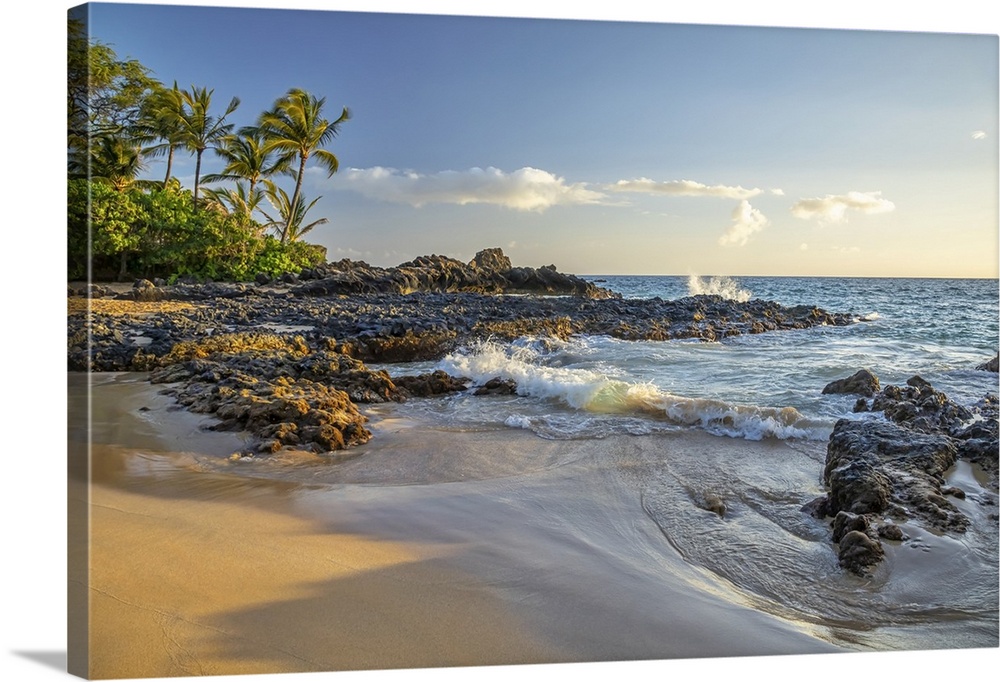 Coastline of Maui with rugged lava rock, a beach and palm trees; Kihei, Maui, Hawaii, United States of America.