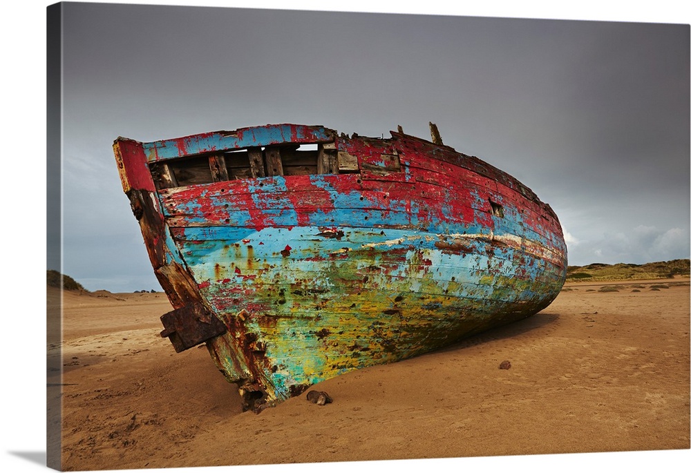 Colourful weathered shipwreck lying in sand dunes at Crow Point, at the mouth of the Taw and Torridge Rivers, near Barnsta...