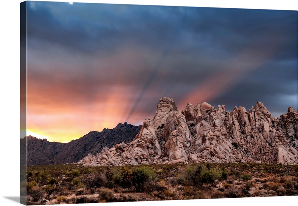 Crepuscular rays at sunset behind rock formations in the Mojave Desert, Kelso, California, United States of America
