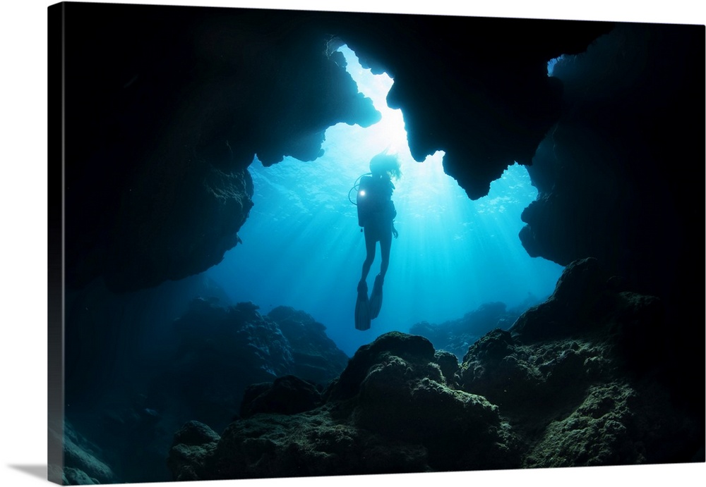 Diver entering a crevice at Yap Cavern's off the very south end of the island of Yap; Yap, Micronesia