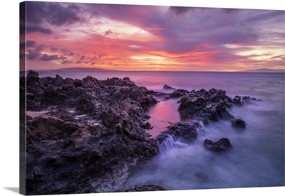 Dramatic sunset over the ocean with waterfalls along the coastline; Wailea, Maui, Hawaii