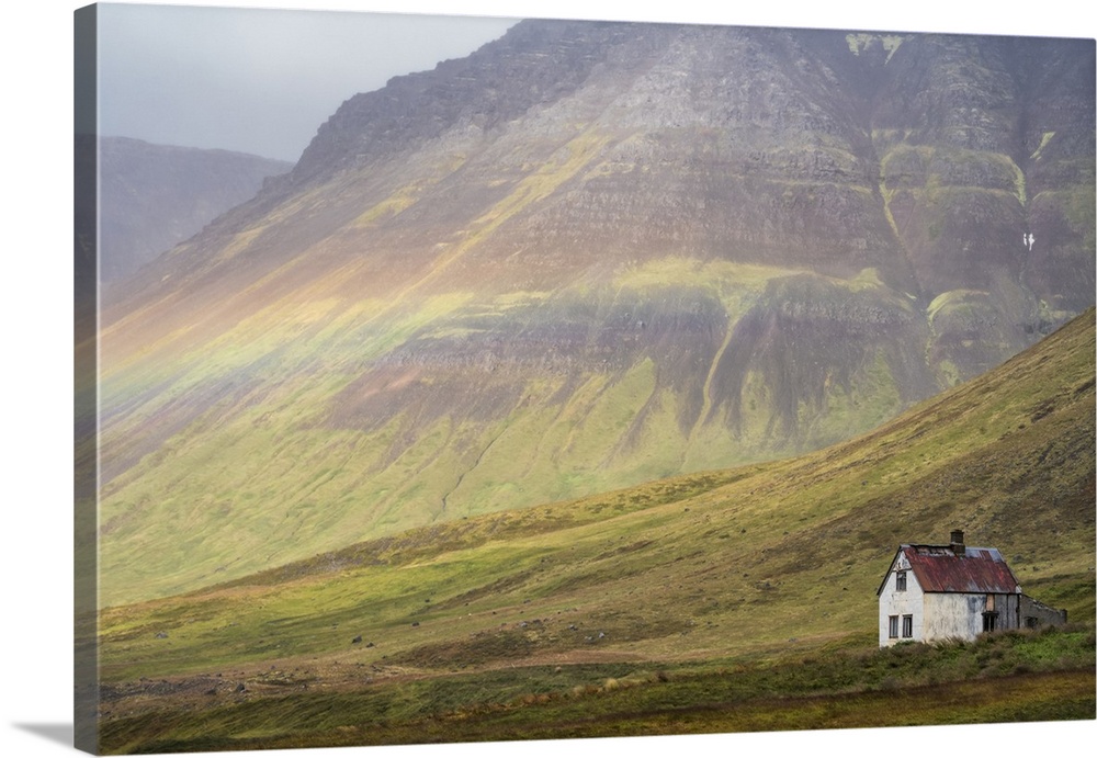 Faint rainbow over an abandoned Iceland homestead; West Fjords, Iceland