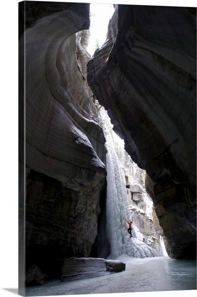 Female Climber Explores Ice Climbing In The Narrows Of Maligne Canyon In Jasper National Park, Alberta, Canada