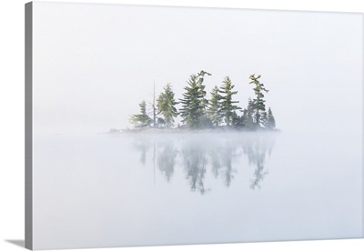 Fog shrouds a small island on Turtle Lake in Ontario's Muskoka Region, Ontario, Canada