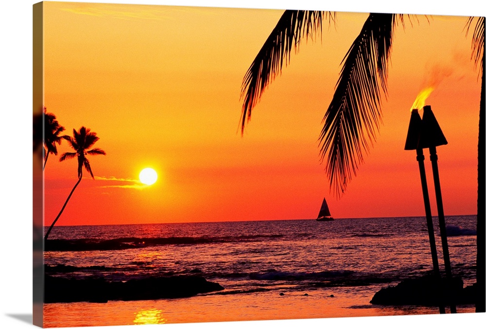 This is a landscape photograph of the sun setting on a tropical beach where all the landscape features have been silhouett...