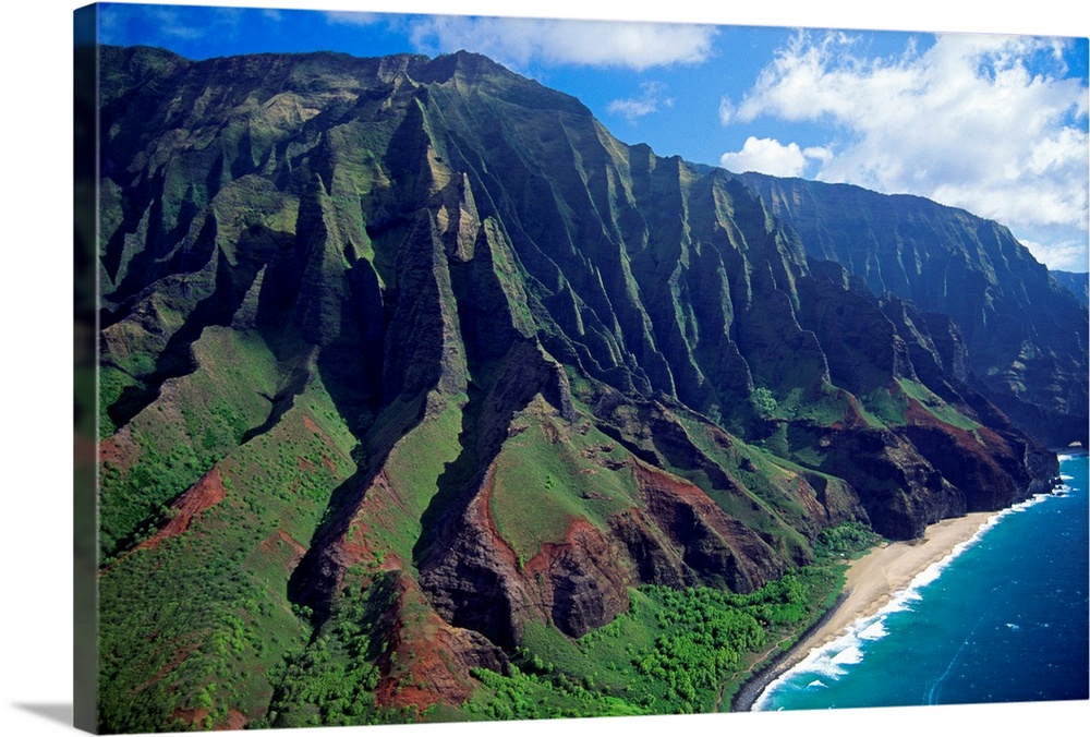 This large piece is an aerial photograph of huge mountains on the coast of a Hawaiian island.