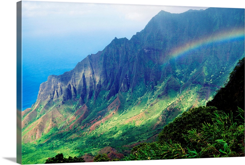 Large canvas photo art of a rainbow in the middle of lush Hawaiian mountains.