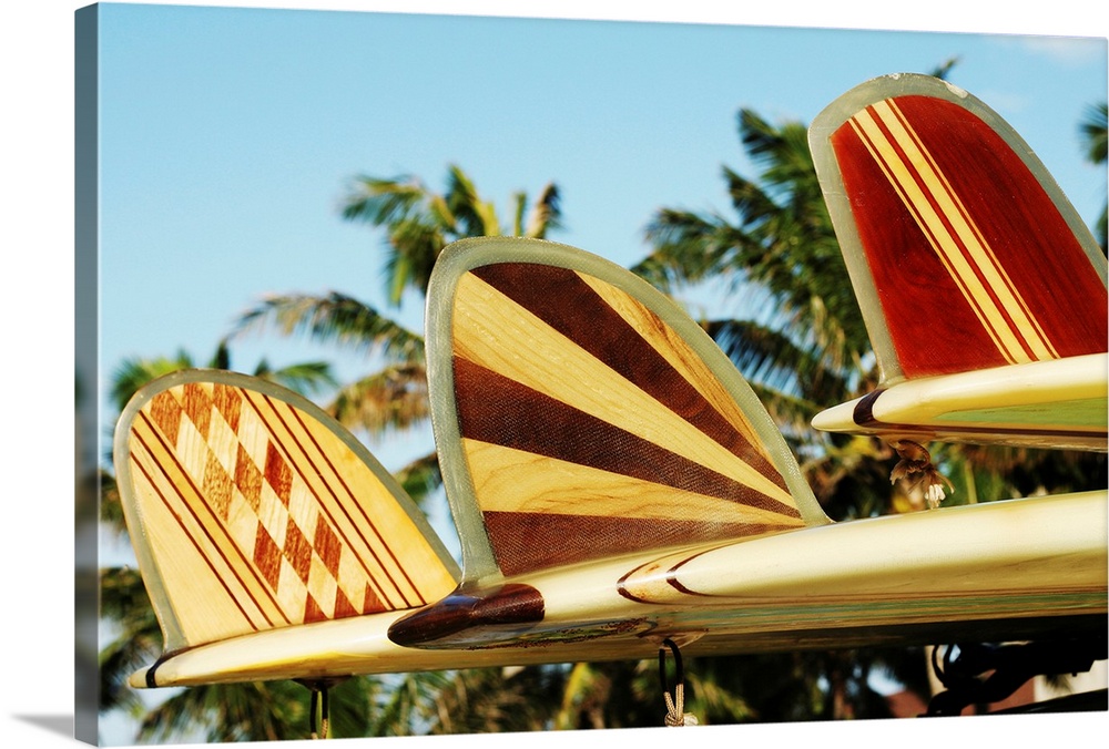 Up-close photograph of three patterned surfboard fins.