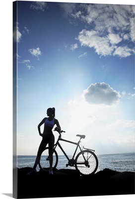 Hawaii, Oahu, Silhouette Of A Woman With A Bike On A Rocky Coastline