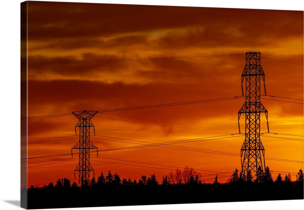 Silhouette of large metal electrical towers with a colorful dramatic sky in the background, Calgary, Alberta, Canada.