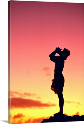 Man Silhouetted At Sunset Blowing A Conch Shell
