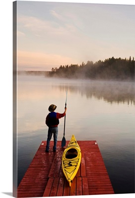 Man Standing By Kayak On Dock In Northwestern Ontario, Lake Of The Woods, Ontario