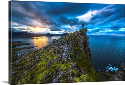 Man standing on top of a sea cliff at sunset along Iceland's Strandir Coast, Iceland