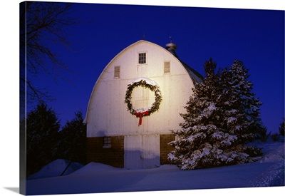 Midwestern barn in Winter snow and last light of the day with a Christmas wreath