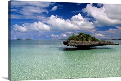 Mushroom island, clear blue water, and a cloud-filled sky.