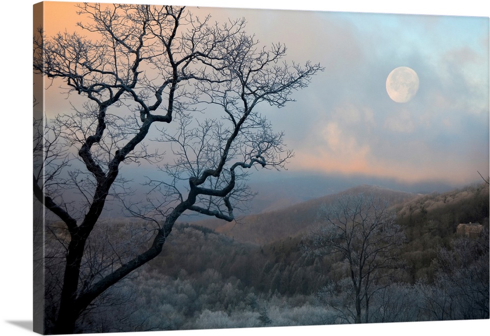 Nearly full moon sets over the mountains at sunrise