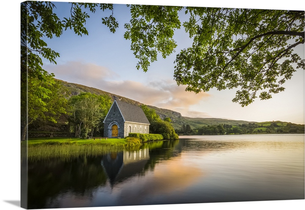 Old chapel of Gougane Barra situated by a lake and framed by green trees at sunrise; Gougane Barra, County Cork, Ireland.
