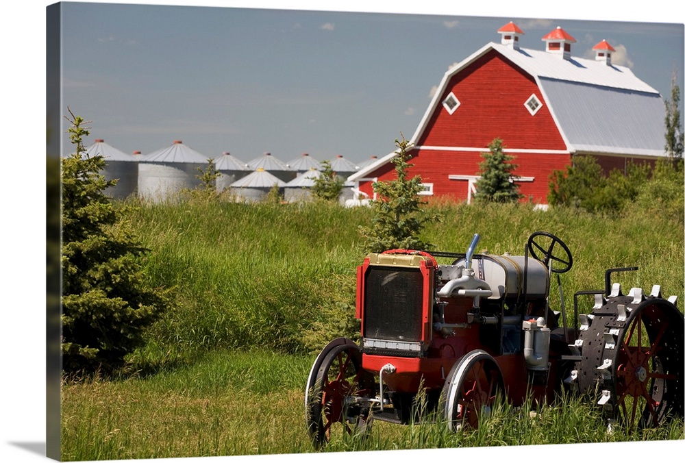 Old Red Tractor In A Field With A Red Barn In The Background, Alberta, Canada