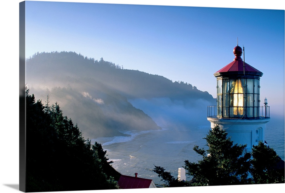 Landscape, close up photograph of the top of Heceta Head Lighthouse, overlooking the coastline as the sun rises in Oregon.