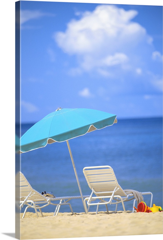 Pair Of Beach Chairs And An Umbrella On White Sand Beach With Blue Skies And Water
