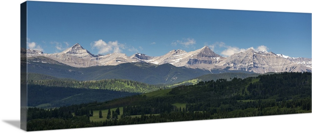 Panorama of foothills and the Canadian Rockies mountain range with blue sky and clouds, West of High River; Alberta, Canada