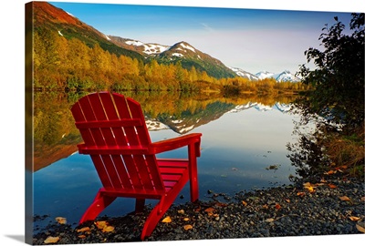 Red Adirondak chair along lakeshore, Alaska
