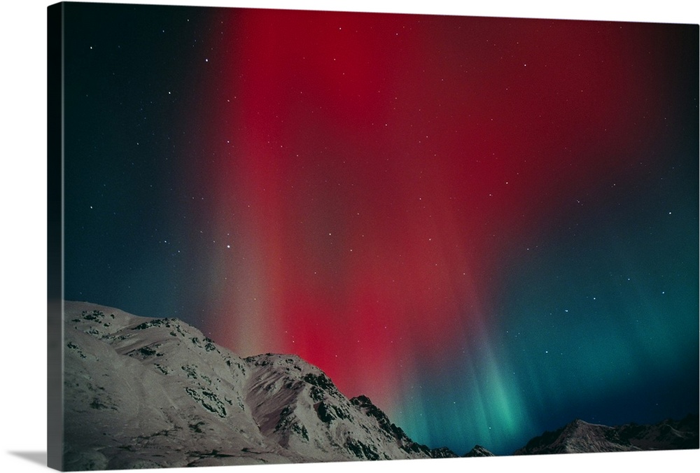 Photo on canvas of an aurora in the night sky above snow covered rugged mountains.