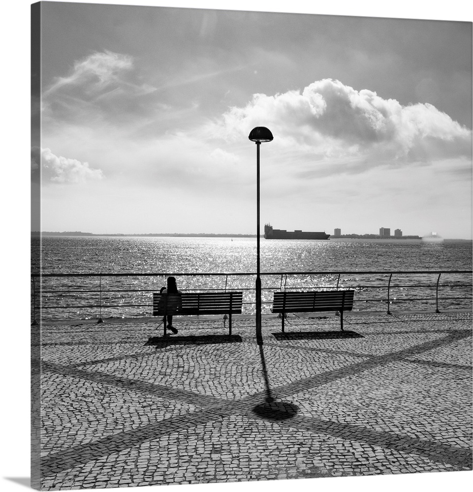Seating along the waterfront with a view of the busy port of Setubal, Portugal. Setubal is a busy port and industrial city...