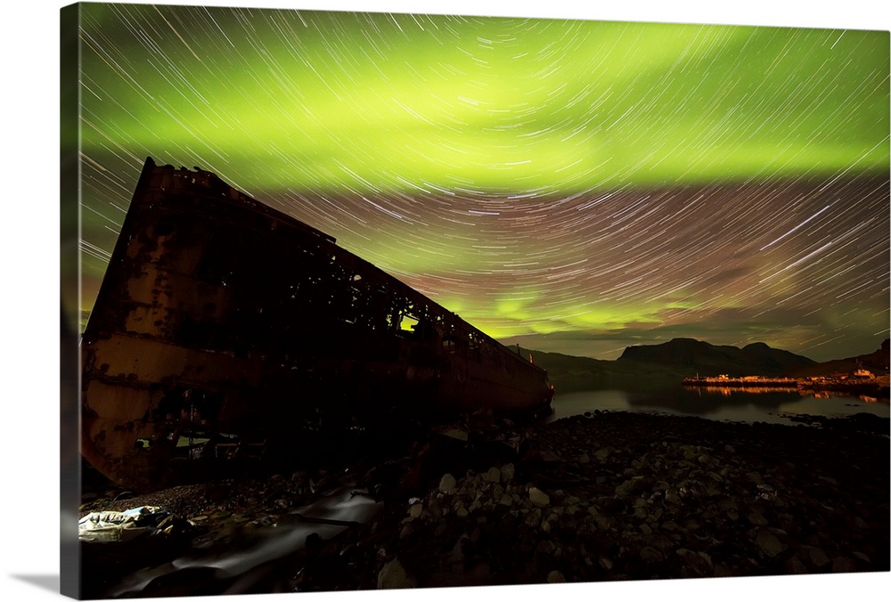 Star trails and northern lights over top the town of Djupavik in the West Fjords of Iceland; Djupavik, Iceland