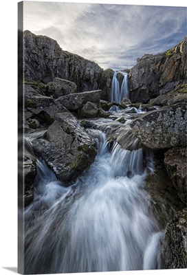 Stream flows over a waterfall along the eastern coast of Iceland