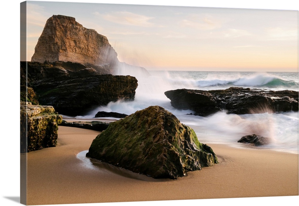 Sunset along the central California coast with waves crashing onto the large rocks on the beach Santa Cruz, California, Un...