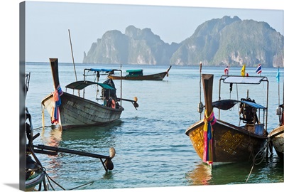 Thailand, Koh Phi Phi, Longtail boats along the shoreline, Mountains in distance