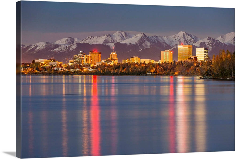 The Anchorage Skyline with the city lights reflected in the water of Knik Arm at high tide, Snow covered Chugach Mountain ...