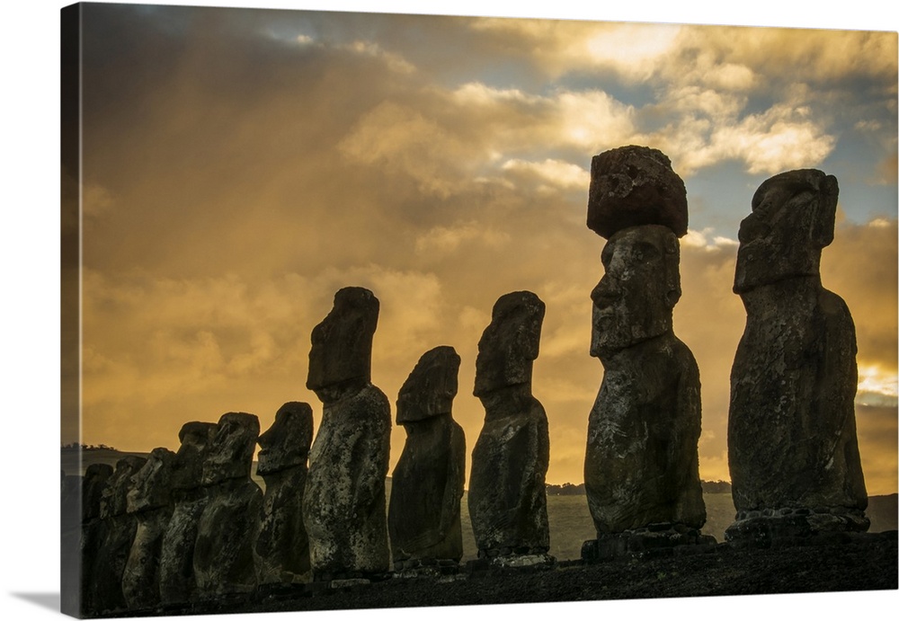 The fifteen moais of Tongariki close-up in decreasing perspective against a colourful sunrise; Easter Island, Chile