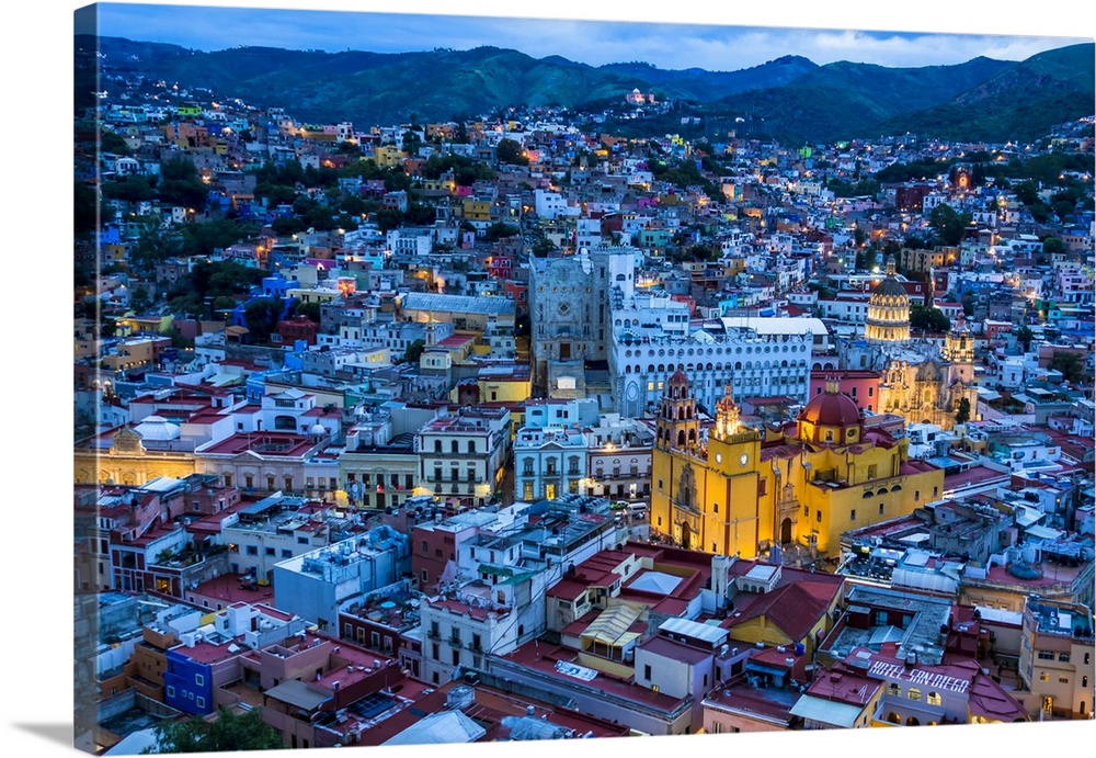 Overview of city at dusk with the Guanajuato Basilica painted in yellow in Guanajuato City, Guanajuato, Mexico