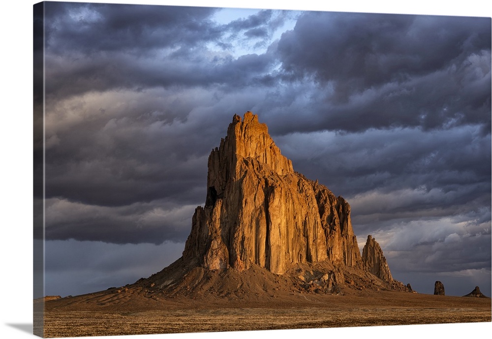 Storm clouds gather over Shiprock, New Mexico. The rising suns illuminates this sacred rock of Navajo people, Shiprock, Ne...