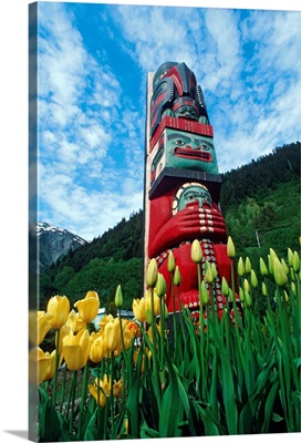 Totem pole with tulips Juneau Southeast Alaska mountains coast summer tourist