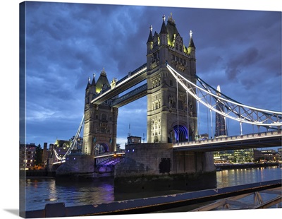 Tower Bridge Illuminated At Dusk And Reflected In The River Thames, London, England